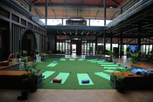 Una gran sala con una gran sala de yoga con colchonetas verdes. en Champions Ranch, en Bāgalūr