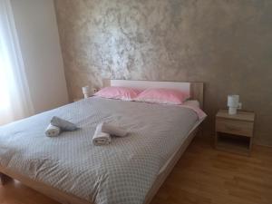 - un lit avec des oreillers et des serviettes roses dans l'établissement App Krivit, à Pula