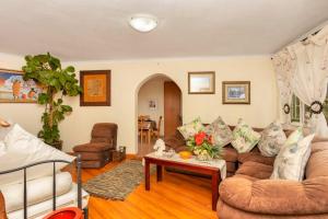 Cottage on Pipers في Sandton: غرفة معيشة بها أريكة وطاولة