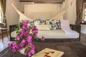 a room with a bed and a table with flowers at Savanna Orinoquia Lodge in Orocué