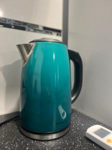a blue kettle sitting on top of a counter at Neuwertiges Apartment mit schnellem WLAN, Glasfaser, Kostenlose Privatparkplatz auch für Transporter geeignet R25 in Freiberg am Neckar