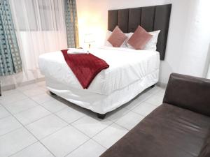 1 dormitorio con 1 cama blanca grande y 1 silla en De Bliss Lodge, en Johannesburgo