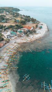 eine Luftansicht auf einen Strand mit Booten im Wasser in der Unterkunft Playa de Bombora Inn in Cabugao