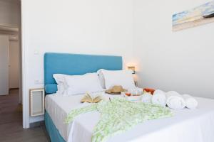 Una cama con toallas y otros artículos. en Helen Beach Front Luxury Villas, en Kastraki Naxou