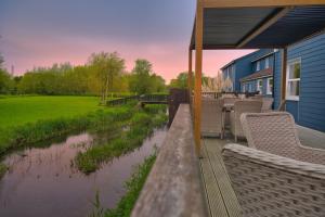 a covered deck with chairs and a river at The Bridge House; BW Signature Collection in Ferndown