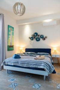 sypialnia z łóżkiem z niebieskimi kocami i żyrandolem w obiekcie Seasons Home San Foca w mieście San Foca