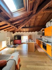 モデナにあるTintoretto 15の木製の天井とオレンジ色のキャビネットを備えた広いキッチン
