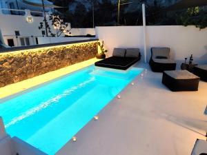 a swimming pool in the middle of a backyard at night at The Magic Luxury Cave Suites in Vóthon