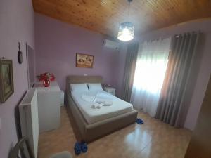 ein kleines Schlafzimmer mit einem Bett und einem Fenster in der Unterkunft George's Apartment in Gjirokastër