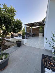 eine Terrasse mit Topfpflanzen und einem Tisch und Stühlen in der Unterkunft Kosaris Cottage in Zipárion