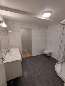 a bathroom with a toilet and a sink and a tub at Leilighet sentralt i Svolvær in Svolvær