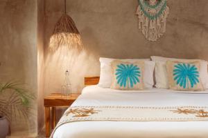 a bedroom with a bed with white sheets and pillows at The Garten Living in Paje +91 photos