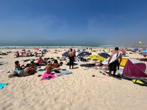 a group of people laying on the beach at Peniche Surf Lodge 1 in Peniche