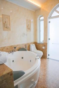 a bathroom with a white tub and a toilet at Benzen villa in Nha Trang