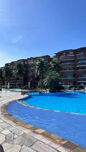 duży niebieski basen przed budynkiem w obiekcie Apartamento 2 suítes em frente praia de camboinhas w mieście Niterói