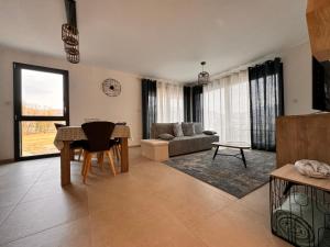 a living room with a table and a couch at Annecy L'Arborea in Pringy