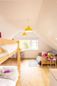 a bedroom with two bunk beds and a couch at Forty Winks Loch Lomond in Balloch