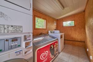 una pequeña cocina con fogones y lavavajillas en Mobil Home 4 personnes 207, en Mens