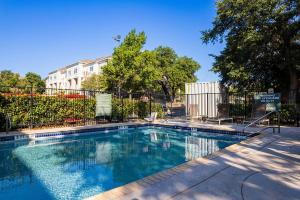 une piscine en face d'une clôture dans l'établissement Blueground Gateway gym pool steps to stadium ATX-248, à Austin