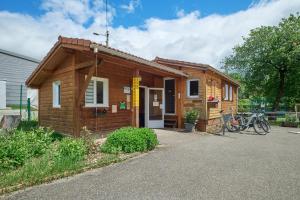 una pequeña casa de madera con una bicicleta estacionada fuera en Mobil Home 4 personnes 207, en Mens