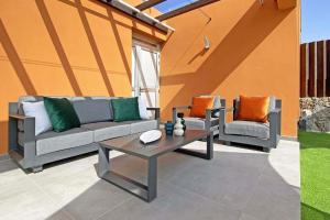une terrasse avec un canapé, deux chaises et une table dans l'établissement Ferienhaus für 6 Personen ca 122 qm in Las Crucitas, Gran Canaria Südküste Gran Canaria, à Maspalomas