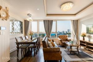 uma sala de estar com uma mesa e cadeiras e uma grande janela em Leman Luxury Apartments 2BR 3BR For Rent In Central em Cidade de Ho Chi Minh