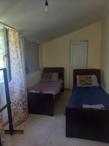 ein kleines Zimmer mit 2 Betten und einem Fenster in der Unterkunft Mera Hostel in P'arts'khanaqanevi