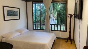 een slaapkamer met een bed en een groot raam bij Casa Vélez: habitación natural in Villamaría