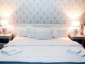 sypialnia z białym łóżkiem i 2 szafkami nocnymi w obiekcie Hotel Nadodrzański Dwór - Nowa Sól w Nowej Soli