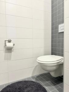a bathroom with a toilet and a black rug at Aardla Cozy Apartment in Tartu +12 photos