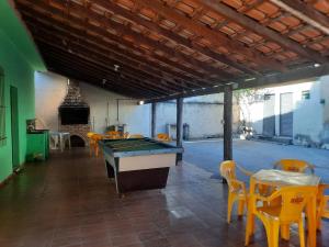 a room with a pool table and tables and chairs at hostel pantaneiro in Aquidauana
