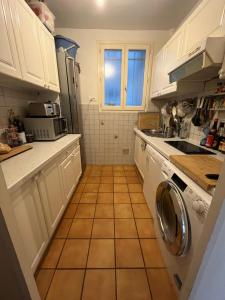 パリにあるChambres jardin des plantes pantheonのタイルフロアのキッチン(白いキャビネット付)