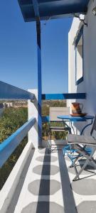Ein Tisch und Stühle auf einem Balkon mit Aussicht in der Unterkunft Molos Pine view in Molos Parou