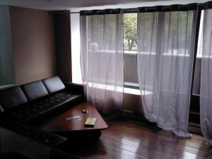 uma sala de estar com um sofá, uma mesa e uma janela em Le Panorachic em Satillieu