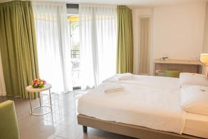 Postel nebo postele na pokoji v ubytování Hotel Nessi Locarno + 34 fotografií