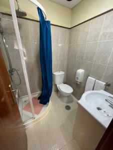 een badkamer met een douche, een toilet en een wastafel bij Areosa in Porto