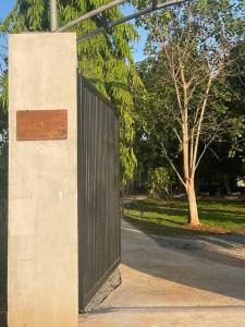 a gate in a wall with a park behind it at Casa Khang - a peaceful cottage close to HCMC in Xã Cam Mỹ