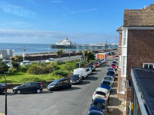 una fila de autos estacionados en un estacionamiento junto a la playa en Millgrove House Apartments, en Eastbourne