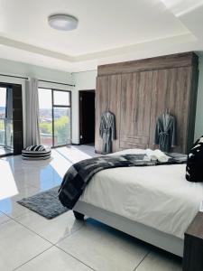 una camera con un grande letto con testiera in legno di Dips And T Hotel & Spa a Bloemfontein