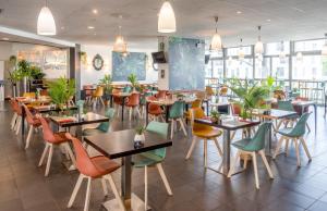 - un restaurant avec des tables et des chaises dans une salle dans l'établissement ibis Paris 17 Clichy-Batignolles, à Paris