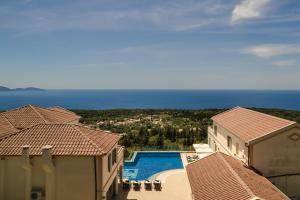 a view of a swimming pool between two buildings at Belle View Hotel - Sea View & Sunset in Mánganos