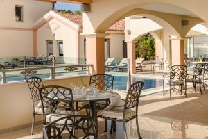 a patio with a table and chairs next to a pool at Belle View Hotel - Sea View & Sunset in Mánganos