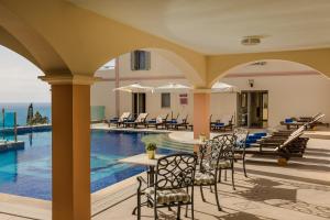 a view of the pool at a resort with tables and chairs at Belle View Hotel - Sea View & Sunset in Mánganos