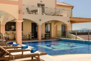 a villa with a swimming pool and a house at Belle View Hotel - Sea View & Sunset in Mánganos