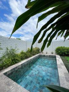 - une piscine avec des carreaux bleus dans l'arrière-cour dans l'établissement Residence Nenuphar, à Abomey-Calavi