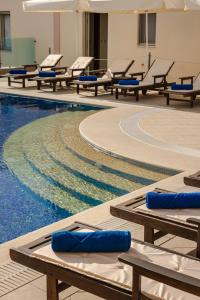 a pool with lounge chairs and a swimming pool at Belle View Hotel - Sea View & Sunset in Mánganos