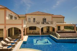 a large house with a swimming pool and chairs at Belle View Hotel - Sea View & Sunset in Mánganos