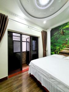 1 dormitorio con 1 cama y una pintura en la pared en HAPPY GUEST HOUSE en Hai Phong