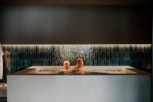 two people in a bath tub with water pouring down at Hotel Del Lago Piediluco Active & SPA in Piediluco