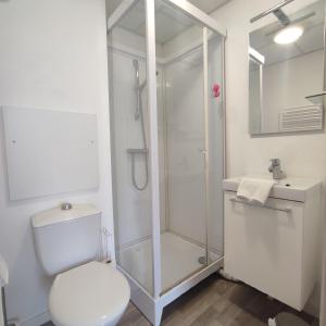 een badkamer met een douche, een toilet en een wastafel bij Neoresid - Résidence du Parc in Reims